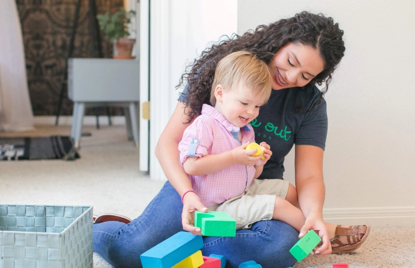 A Time Out Sitter playing blocks with a child while babysitting.